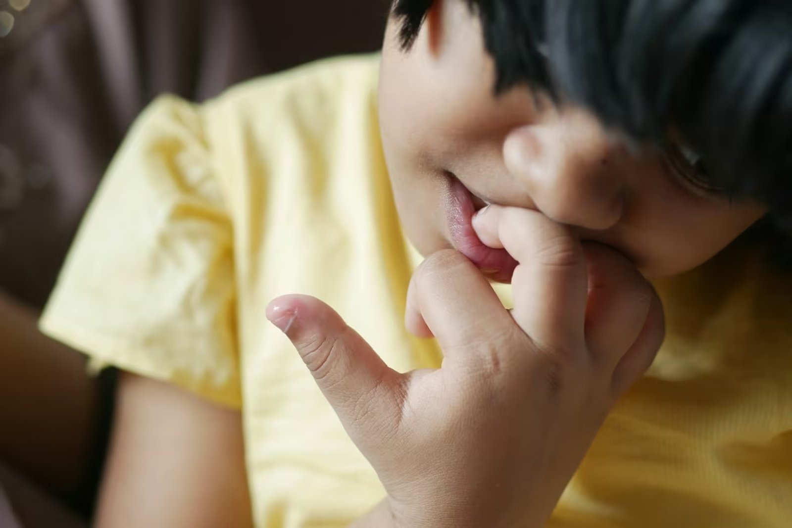 child girl biting her nails at home,