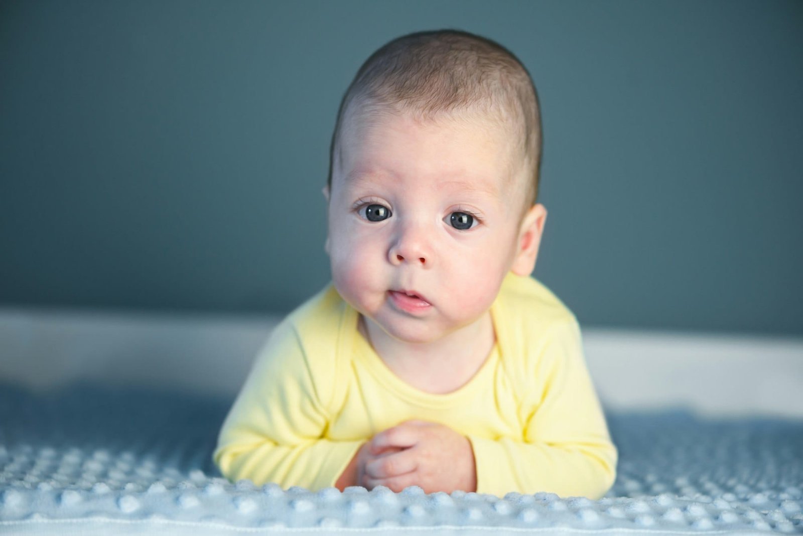 Newborn baby boy on blue carpet closeup